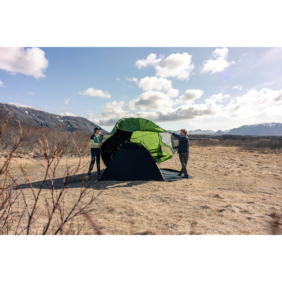 Couple putting the fly over the canopy in the outdoors