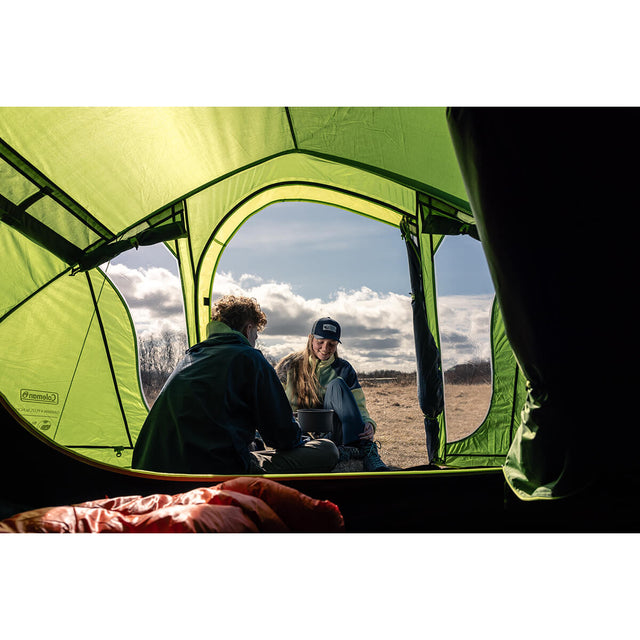 View from inside the bedroom - couple either side of a cookpot setup with one inside the tent, one out