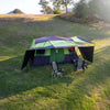 3/4 top view of tent pitched at campsite, couple of chairs under front awning