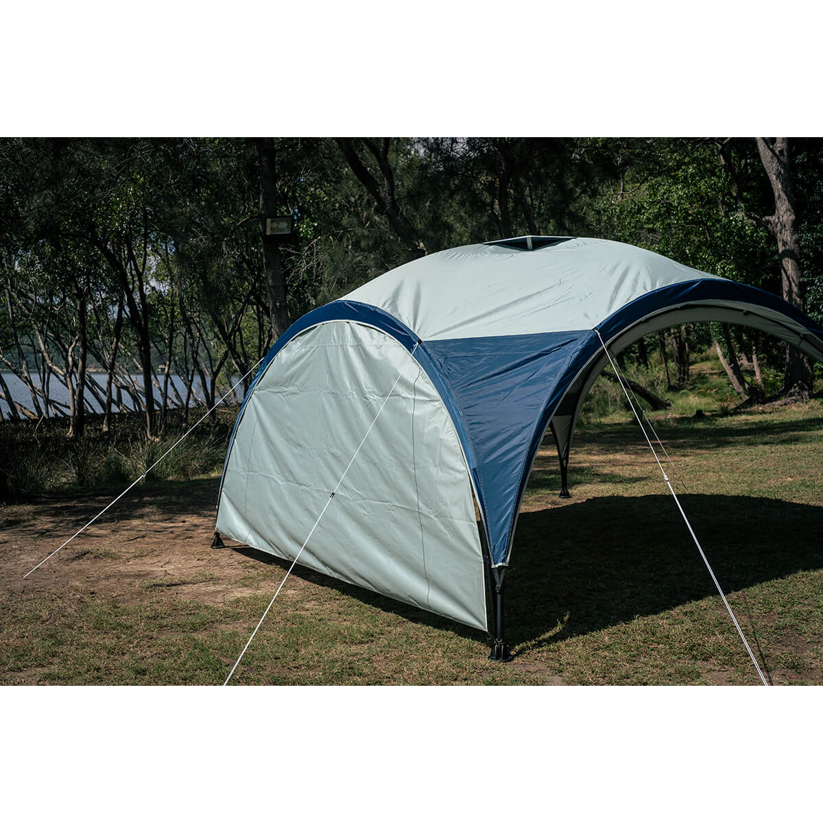 3/4 view of sunwall attached to an Event 12 Deluxe Shelter with guylines attached in the outdoors