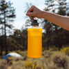 Golden Yellow mostly filled with water held up by carry handle