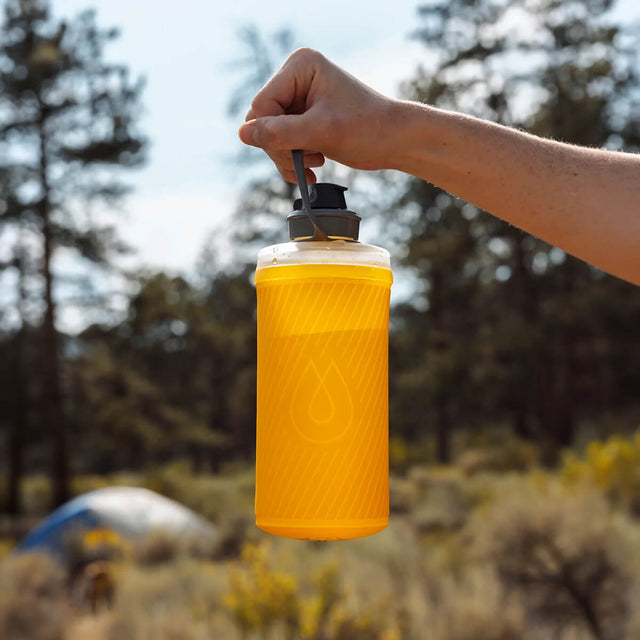 Golden Yellow mostly filled with water held up by carry handle