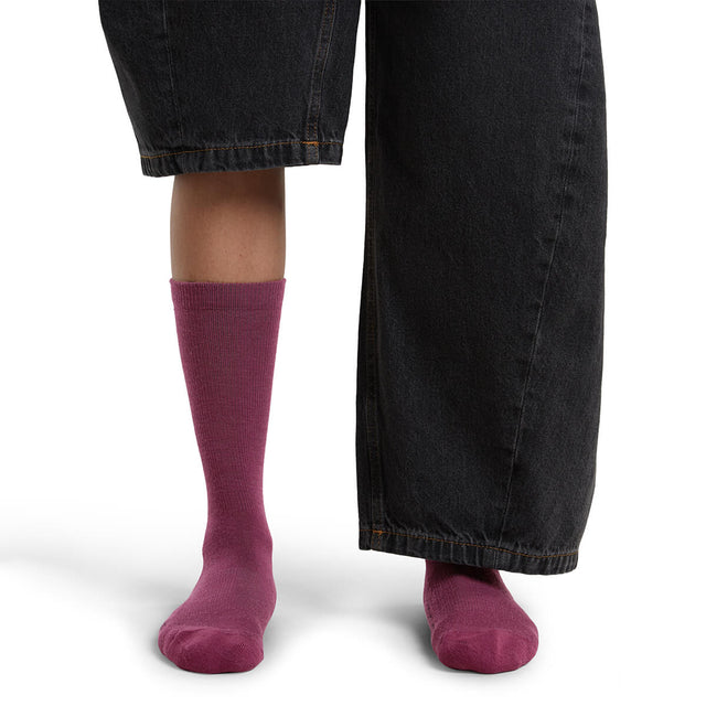 Dk Berry on model, front view, one trouser leg up, one down