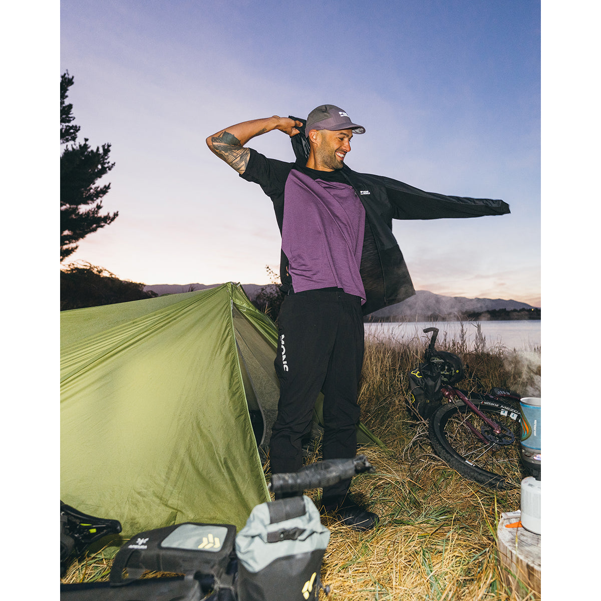 Black, worn in the outdoors outside a tent and bike