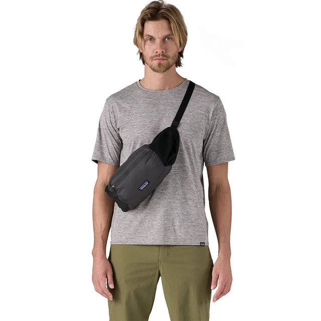 Black carried as a crossbody pack at front by male model