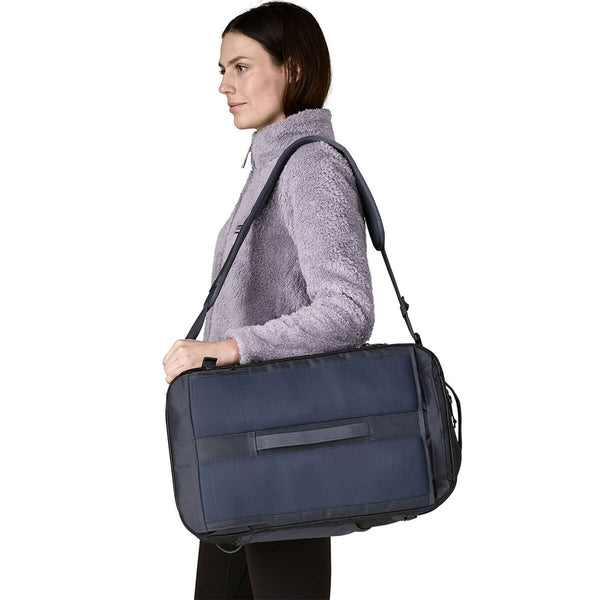 Smolder Blue w/Forge Grey carried as satchel by female model, backpanel out