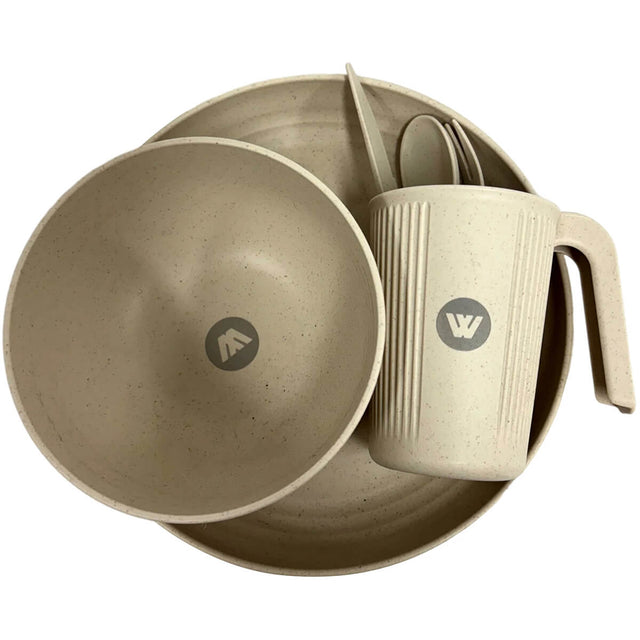 Top view of beige plate with bowl and sideways-lying cup with cutlery on top