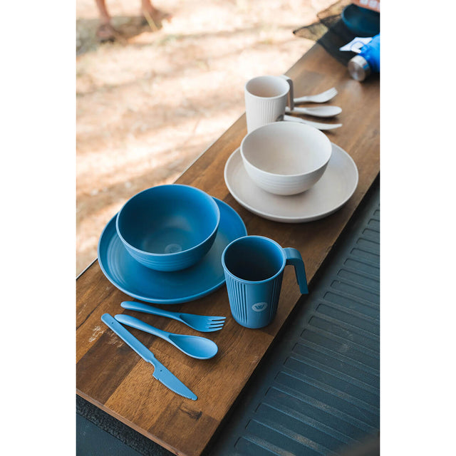 Two sets laid out in the outdoors, one of each colour
