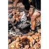 In use with embers on top and being lifter by gloved hand