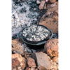 In use adjusting embers on top of a camp oven