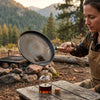 Using spout to pour left-over oil into a bottle in the outdoors