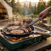 In use cooking meat on a camp stove in the outdoors