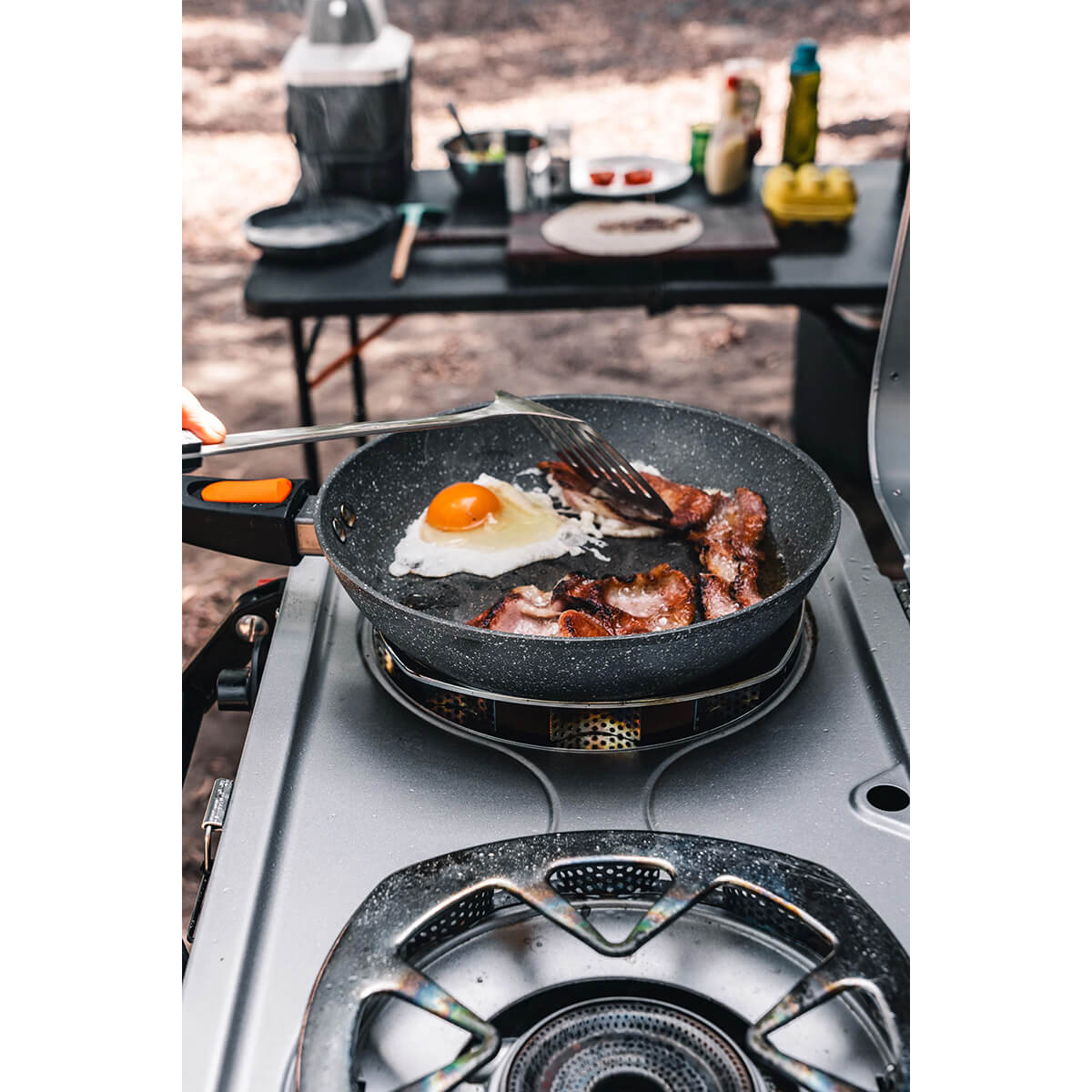 In use cooking eggs and bacon at a camp kitchen