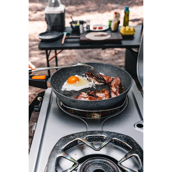 In use cooking eggs and bacon at a camp kitchen
