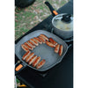 In use cooking sausages on a stove in the outdoors