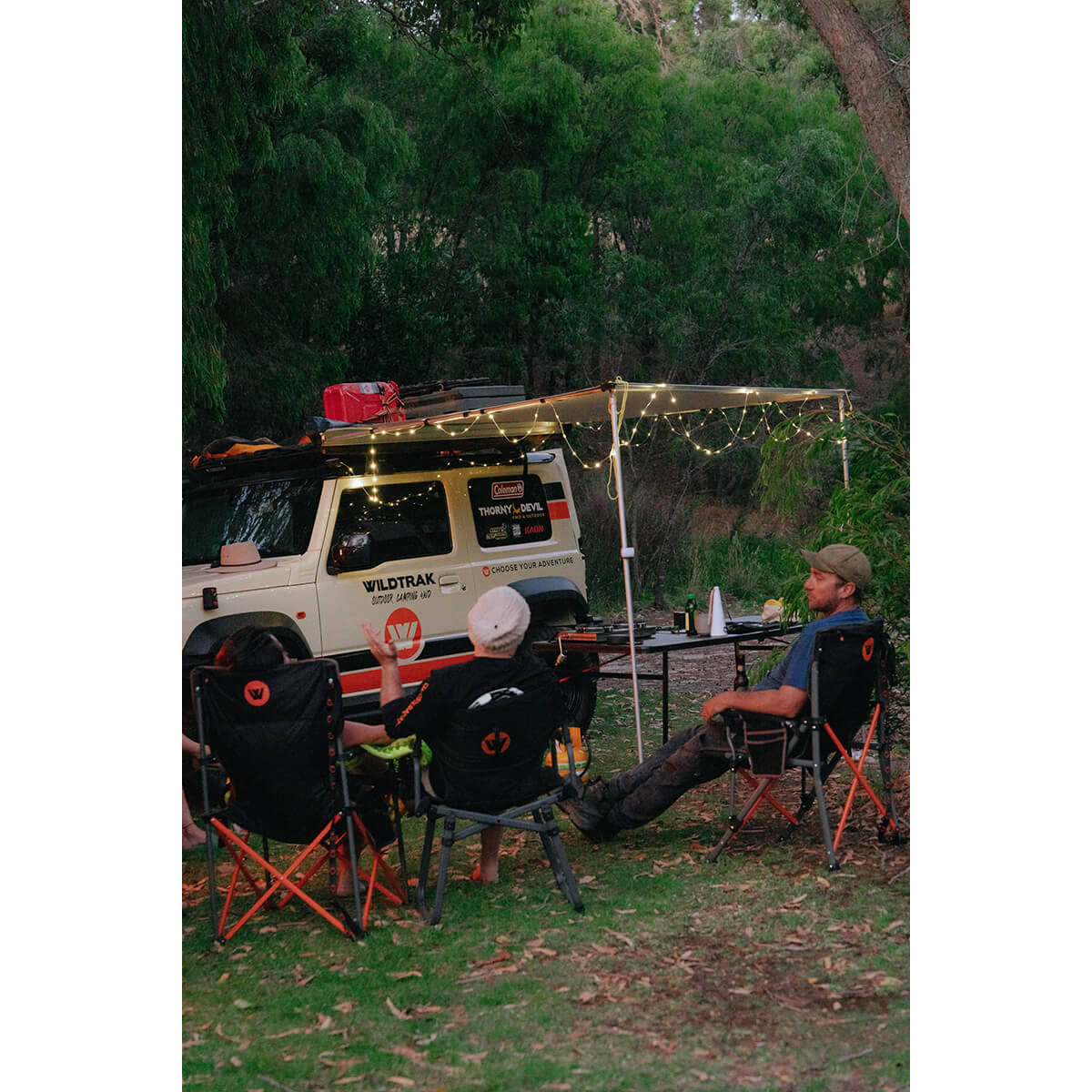 In use on an awning off a vehicle, table and chairs in use underneath