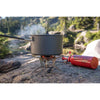 With pot being heated on the stove on an uneven rocky surface