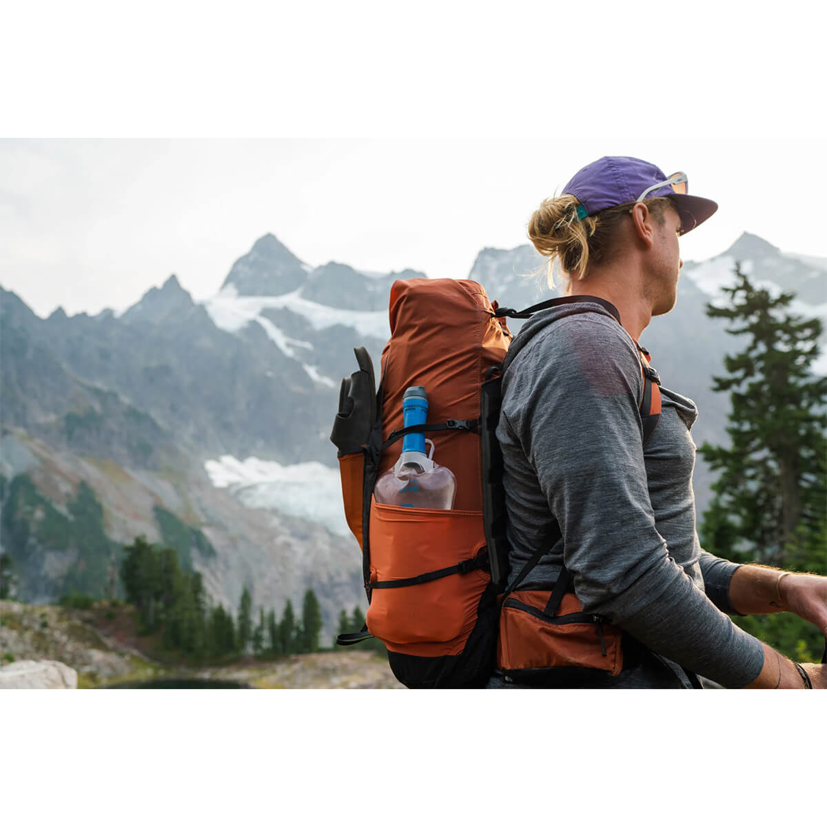 Filled system in side pocket of a pack on a trampers back in the mountains