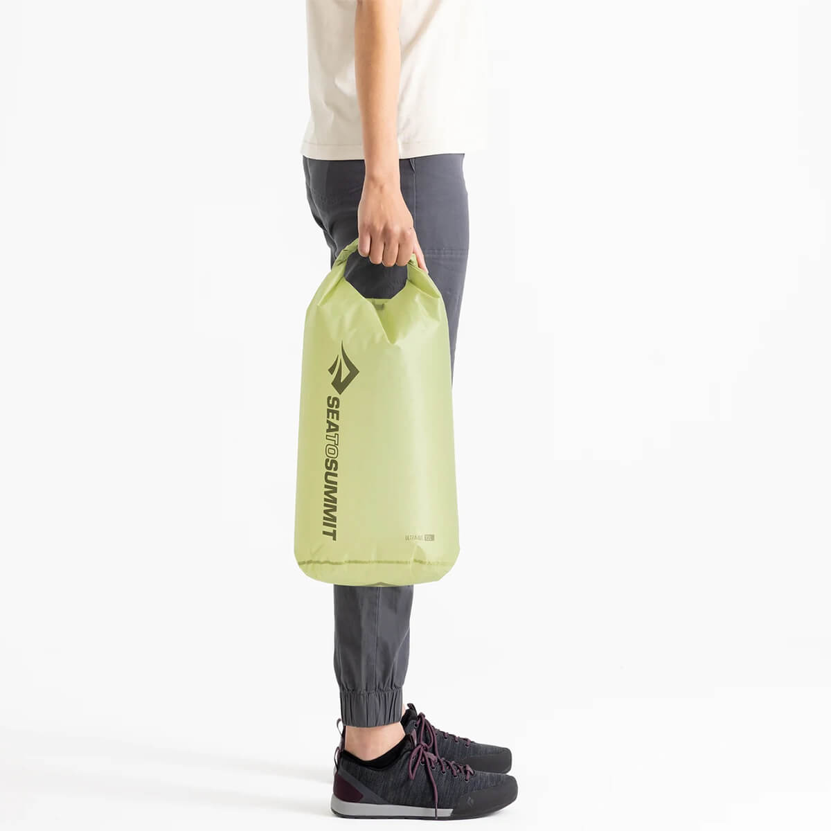 Model carrying 13-litre bag in Tarragon